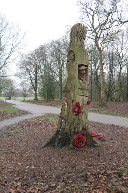 Woodbank Park, Stockport Carved tree war memorial with wreaths of poppies.